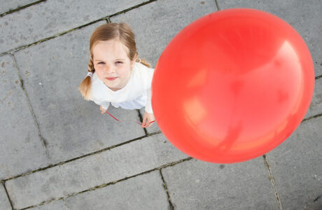 Kleines Mädchen mit rotem Luftballon